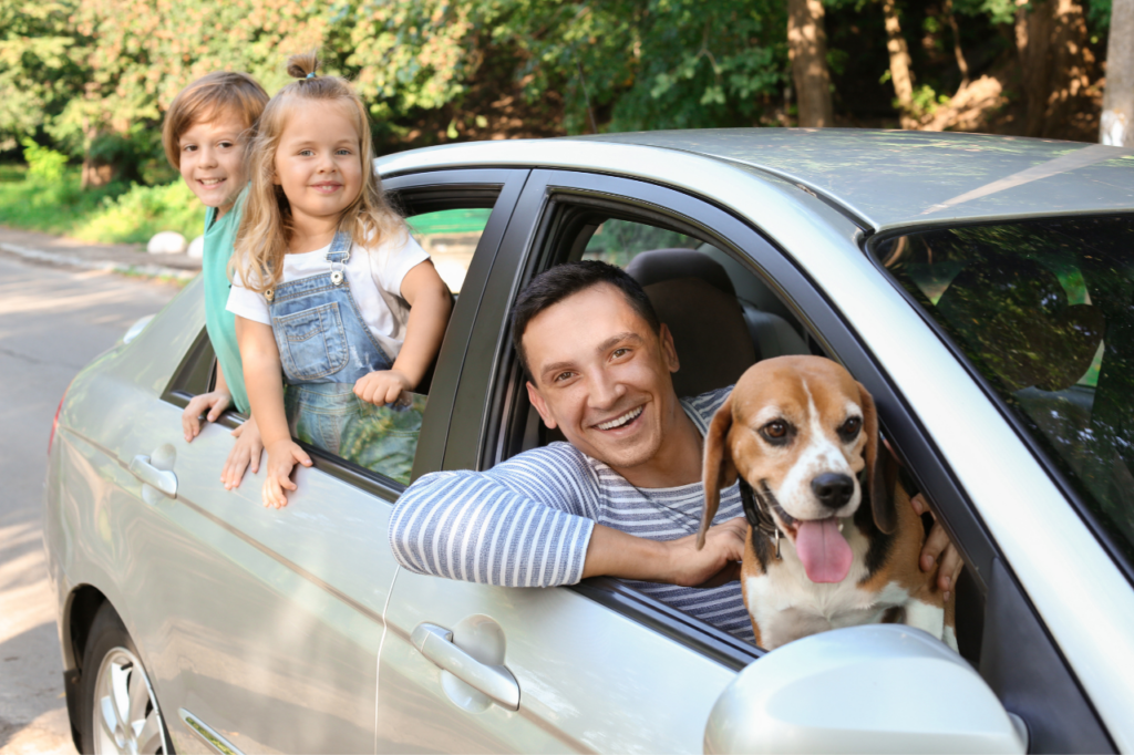 Famille en vacances avec leur chien dans la voiture.